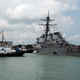 In this Aug. 21, 2017 photo, tugboats from Singapore assist the guided-missile destroyer USS John S. McCain as it steers towards a nearby navy base following a collision with a merchant vessel.